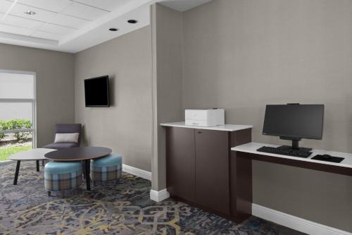 a room with a desk with a computer and a table at Residence Inn Tampa Oldsmar in Oldsmar