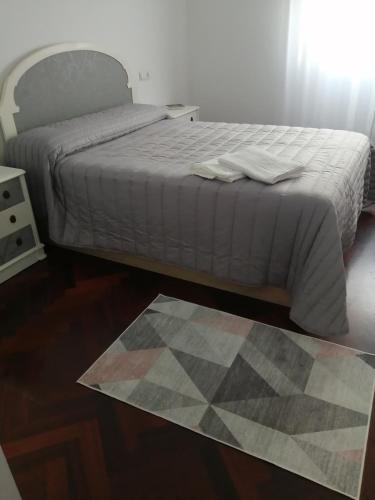 a bedroom with a bed and a rug on the floor at O PISIÑO in Cambados
