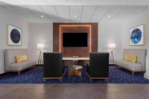 a waiting room with chairs and a table and a tv at Courtyard by Marriott San Diego Miramar in San Diego