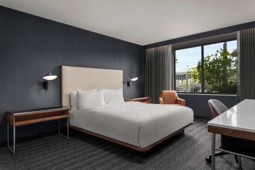 a bedroom with a bed and a large window at Courtyard by Marriott San Diego Miramar in San Diego