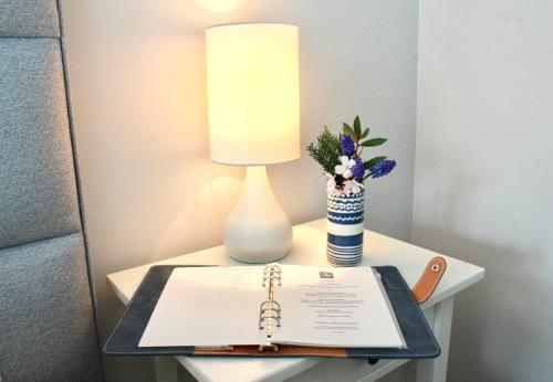 a table with a lamp and a book on it at The Bosham Boathouse in Chichester