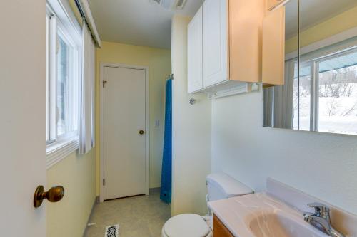 a bathroom with a sink and a toilet and a window at Cozy Anchorage Vacation Rental with Deck, Gas Grill in Anchorage