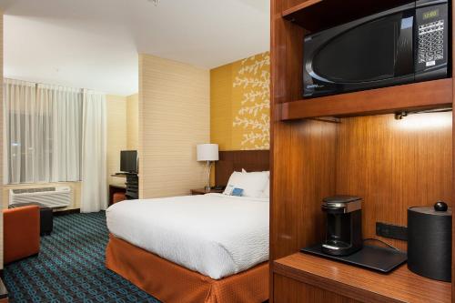 a hotel room with a bed and a flat screen tv at Fairfield Inn & Suites by Marriott Vernon in Vernon