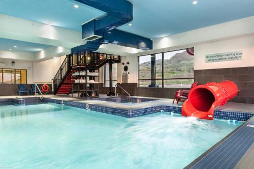 a large swimming pool with a red slide in a building at Fairfield Inn & Suites by Marriott Vernon in Vernon