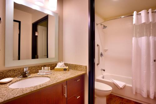a bathroom with a sink and a toilet and a mirror at TownePlace Suites by Marriott Salt Lake City-West Valley in West Valley City