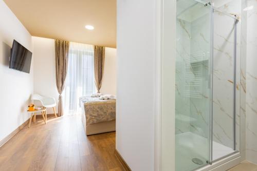 1 dormitorio con ducha de cristal y 1 cama en Luxury Rooms Fetivi en Split