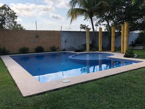 ein kleiner Pool in einem Garten mit einem Zaun in der Unterkunft Hermosa Casa Ikal en Acapulco in Barra de Coyuca