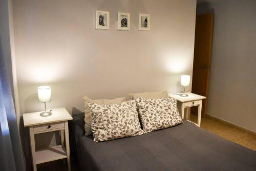 ein Schlafzimmer mit einem Bett mit zwei Nachttischen in der Unterkunft Departamento céntrico para disfrutar en familia in Sagunt