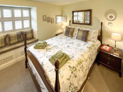 a bedroom with a bed and a window at The Barn At Woodland View in Barlow