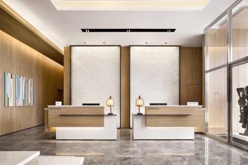 a lobby of a hotel with two reception desks at Fairfield by Marriott Busan Songdo Beach in Busan