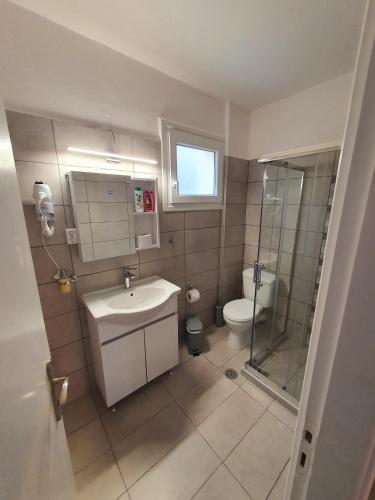 a bathroom with a toilet and a sink and a shower at BELLA DE LUX RESIDENCE in Kato Korakiana
