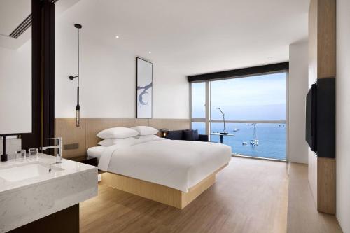 a bedroom with a bed and a view of the ocean at Fairfield by Marriott Busan Songdo Beach in Busan