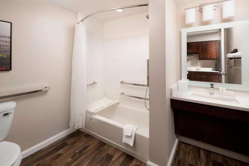 a bathroom with a sink and a tub and a toilet at Towneplace Suites By Marriott Louisville Northeast in Louisville