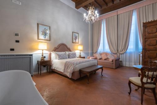 a bedroom with a bed and a couch and windows at Dimora del Cardinale - Residenza d'Epoca in Florence