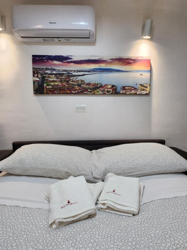 a bed with two white towels on top of it at Suite SANTA CHIARA in Naples