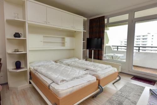 a bedroom with two beds and a large window at Haus "Panorama" Appartement PAN069 in Duhnen