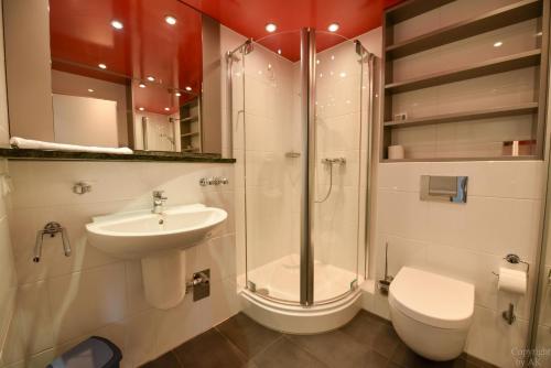 a bathroom with a shower and a toilet and a sink at Haus "Panorama" Appartement PAN069 in Duhnen