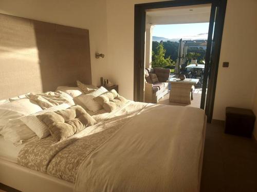 a large white bed in a room with a window at SUITE 20m2 DANS VILLA PISCINE JACUZZI in Gattières