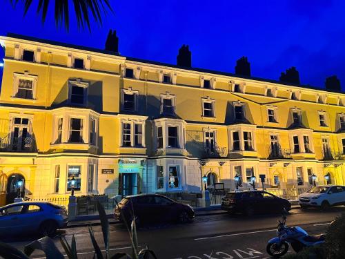 a large white building with cars parked in front of it at Merrion Hotel in Llandudno