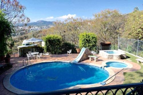a large swimming pool in a yard with a patio at Casa de Descanso en Rancho San Diego Ixtapan de la Sal in Ixtapan de la Sal