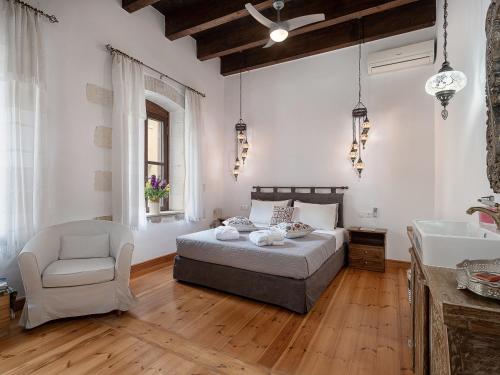 1 dormitorio con cama, silla y lavamanos en Venetian Palace Chania, en La Canea