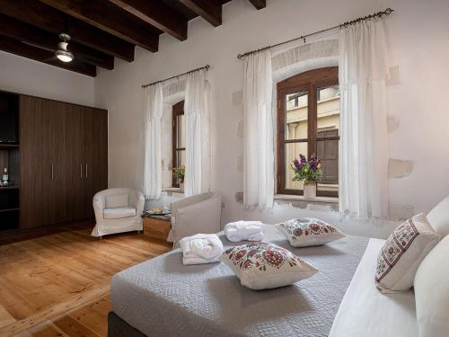 a large room with two beds and a window at Venetian Palace Chania in Chania