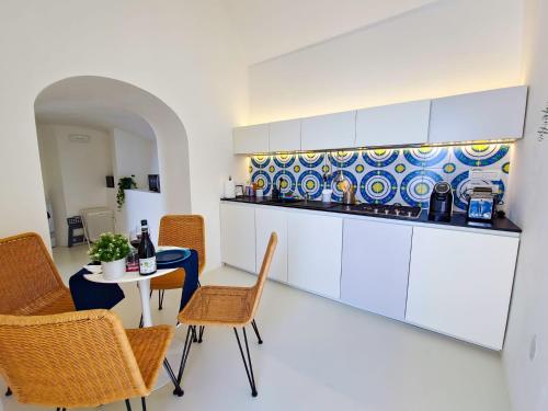 une cuisine avec une table, des chaises et un comptoir dans l'établissement La Pigolina, à Positano