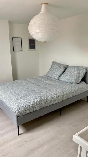 ein Bett in einem Schlafzimmer mit einer weißen Wand in der Unterkunft Maisonette Tran in Lille