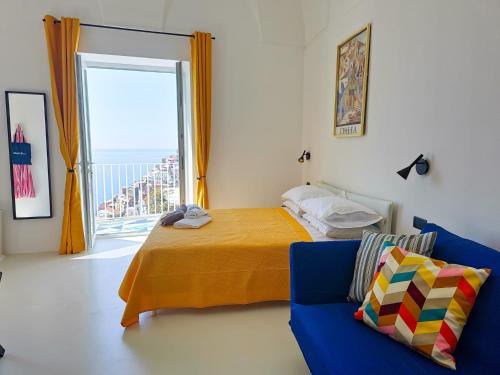 a bedroom with a bed and a couch and a window at La Pigolina in Positano