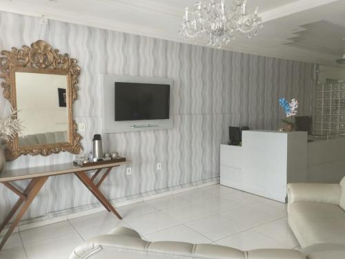 a living room with a mirror and a couch at Hotel Novo Sol in Petrolina