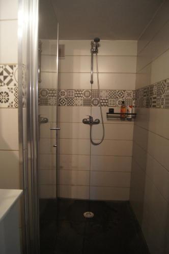 um chuveiro com uma porta de vidro na casa de banho em Chez BEN avec tout le confort clim wifi Netflix gratuit em Castres
