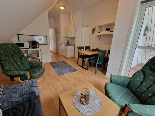a living room with two chairs and a table at Undredal Fjord Apartments in Undredal