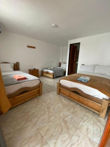 a bedroom with two beds and a tiled floor at Hotel la Victoria in San Roque