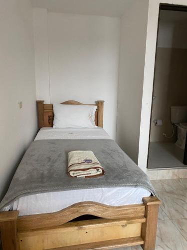 a bed with a blanket and a mirror in a room at Hotel la Victoria in San Roque