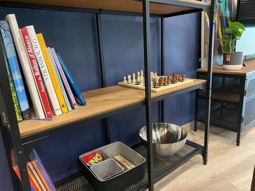 a book shelf with a chess board on it at Duplex By Aurelle 2 in Schiltigheim
