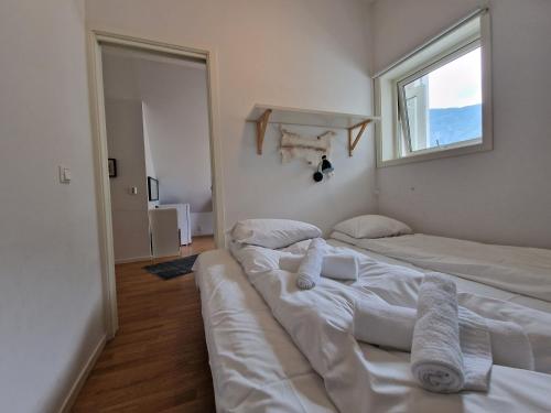 two beds sitting in a room with a window at Undredal Fjord Apartments in Undredal