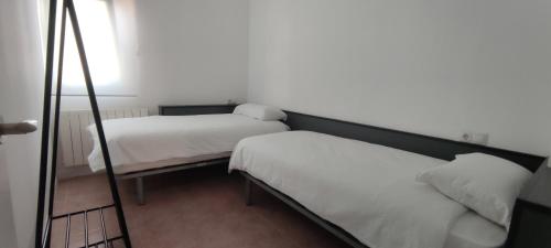 1 Schlafzimmer mit 2 Betten und einem Spiegel in der Unterkunft Estudio San Julián in Teruel