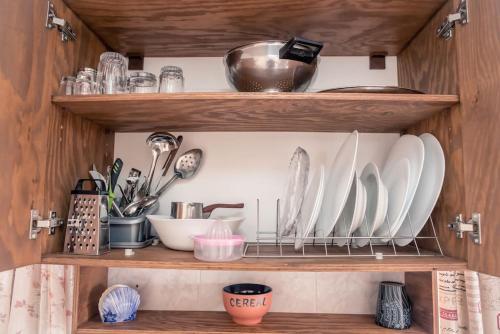 a shelf with plates and utensils in a kitchen at Jacob's Sunrise cottage in Kissamos