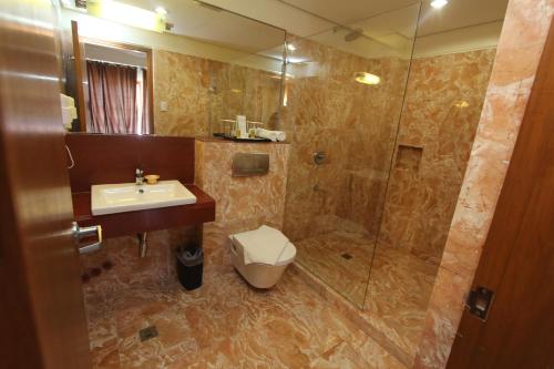 a bathroom with a shower and a sink and a toilet at Crown Regency Beach Resort in Boracay