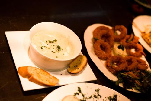 a table with a bowl of dip and some onion rings at Lakeshore Banani in Dhaka