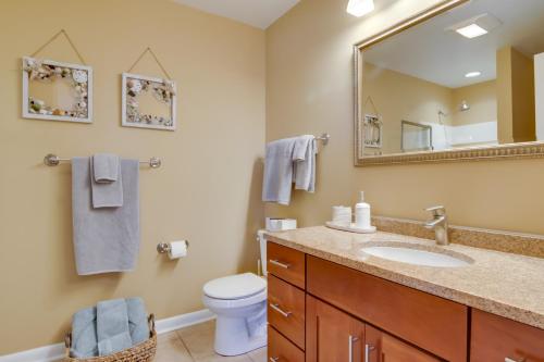 a bathroom with a sink and a toilet and a mirror at Condo with 2 Balconies and 3 Pools Less Than 2 Mi to Beach! in Rehoboth Beach
