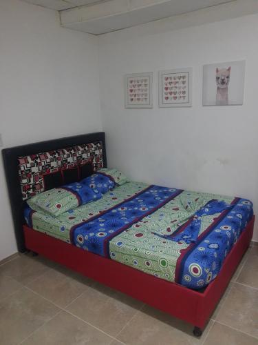 ein Bett mit blauer Decke in einem Schlafzimmer in der Unterkunft Apartaestudio buenos aires in Barrancabermeja