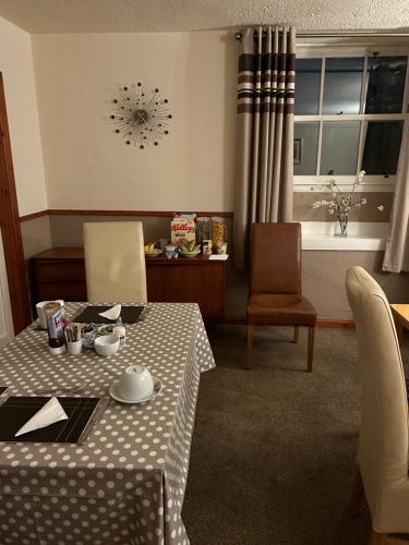 a dining room with a table and chairs and a window at Roselodge Guest House in Aberdeen
