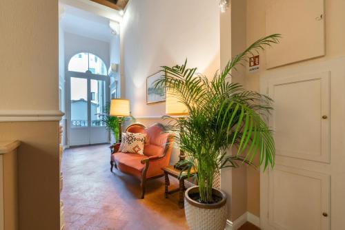 a living room with a chair and a plant at Dimora del Cardinale - Residenza d'Epoca in Florence