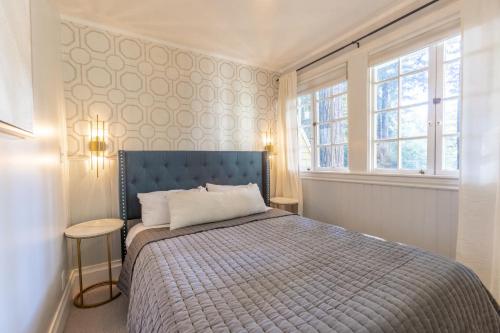 a bedroom with a blue bed and two windows at Boho Manor in Monte Rio