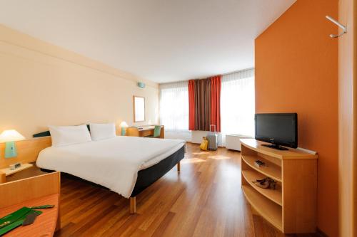 a hotel room with a bed and a television at ibis Bamberg Altstadt in Bamberg