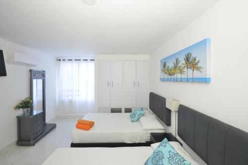 1 dormitorio con 2 camas y espejo en Apartamento Nuevo Conquistador, en Cartagena de Indias
