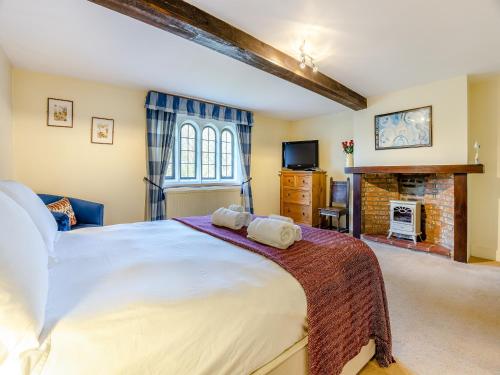 a bedroom with a large bed and a fireplace at Islington Hall in Tilney All Saints
