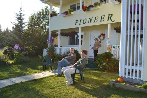 two people sitting in chairs outside of a house at Pioneer Inn Downtown in Homer