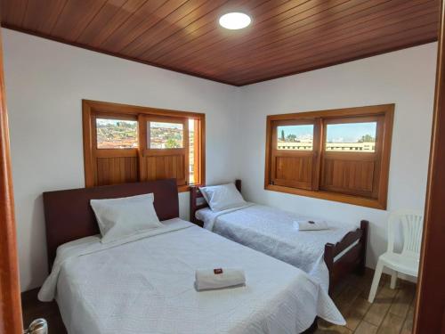 a bedroom with two beds and a wooden ceiling at VILLA GÓMEZ in Zapatoca